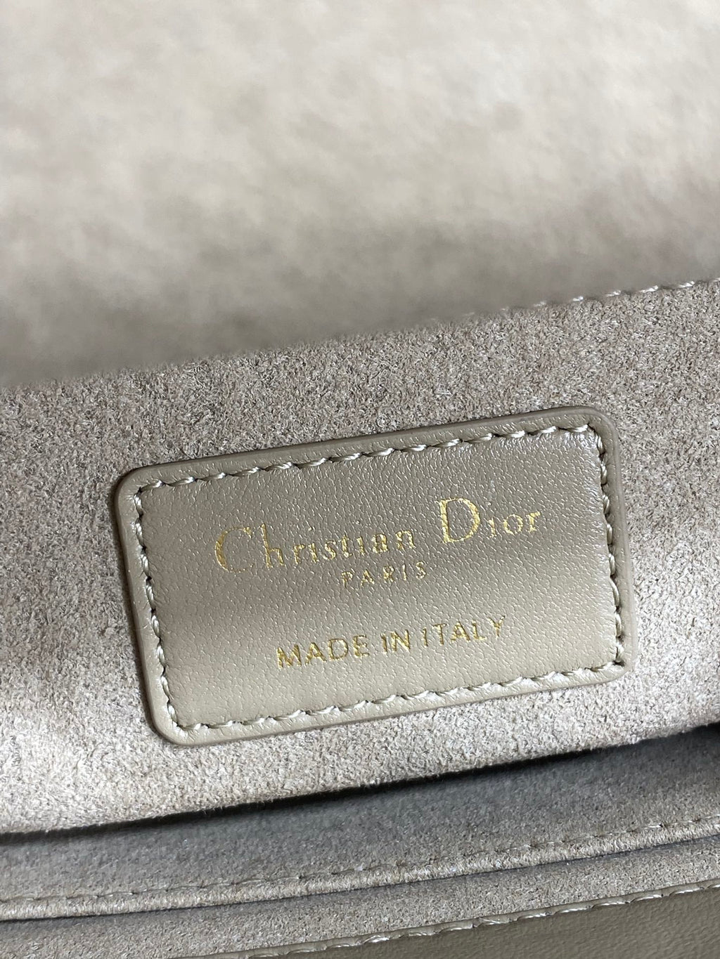 Dior brand label on quilted handbag reading “Christian Dior” and “Made in Italy”