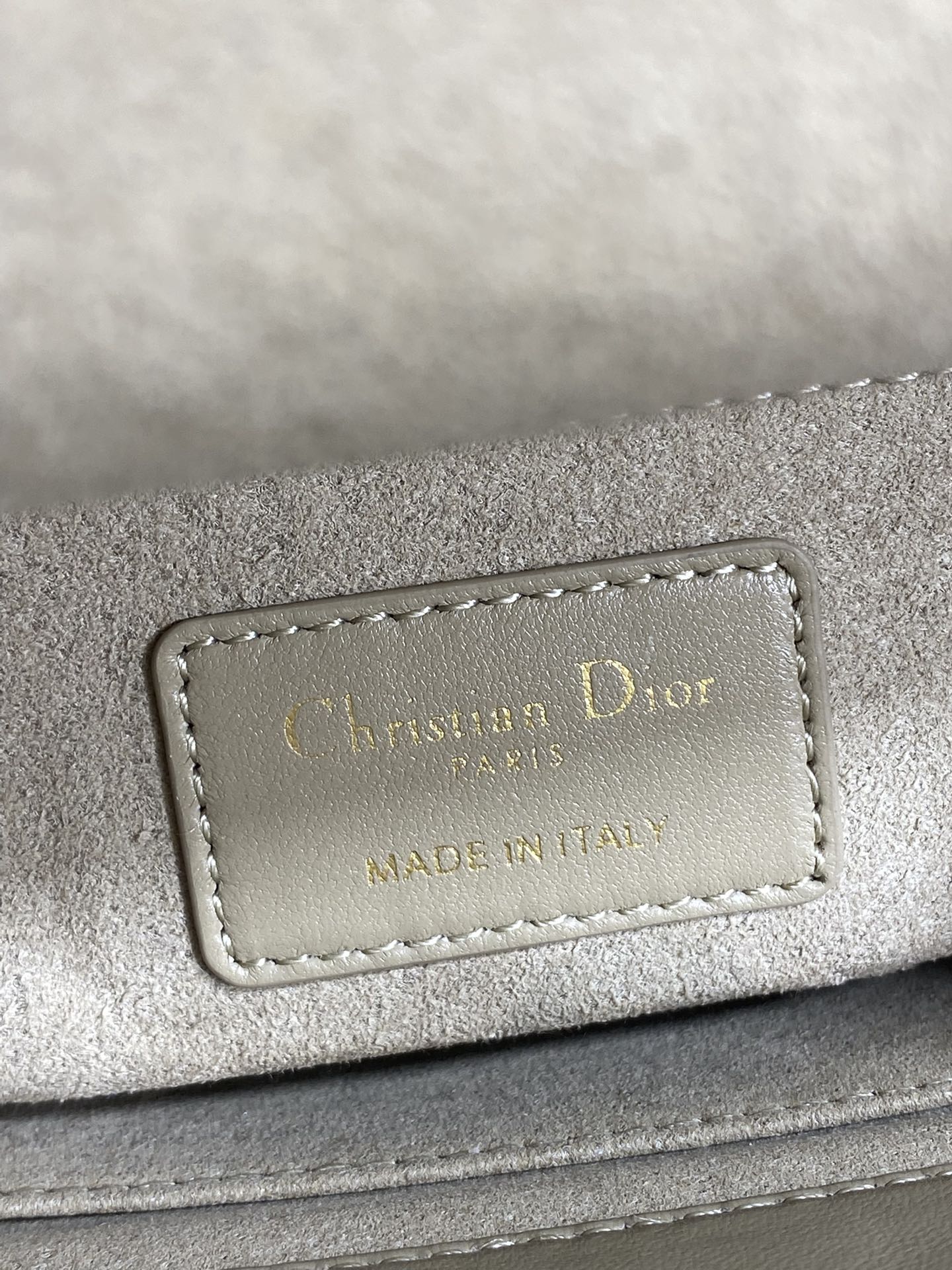 Dior brand label on quilted handbag reading “Christian Dior” and “Made in Italy”