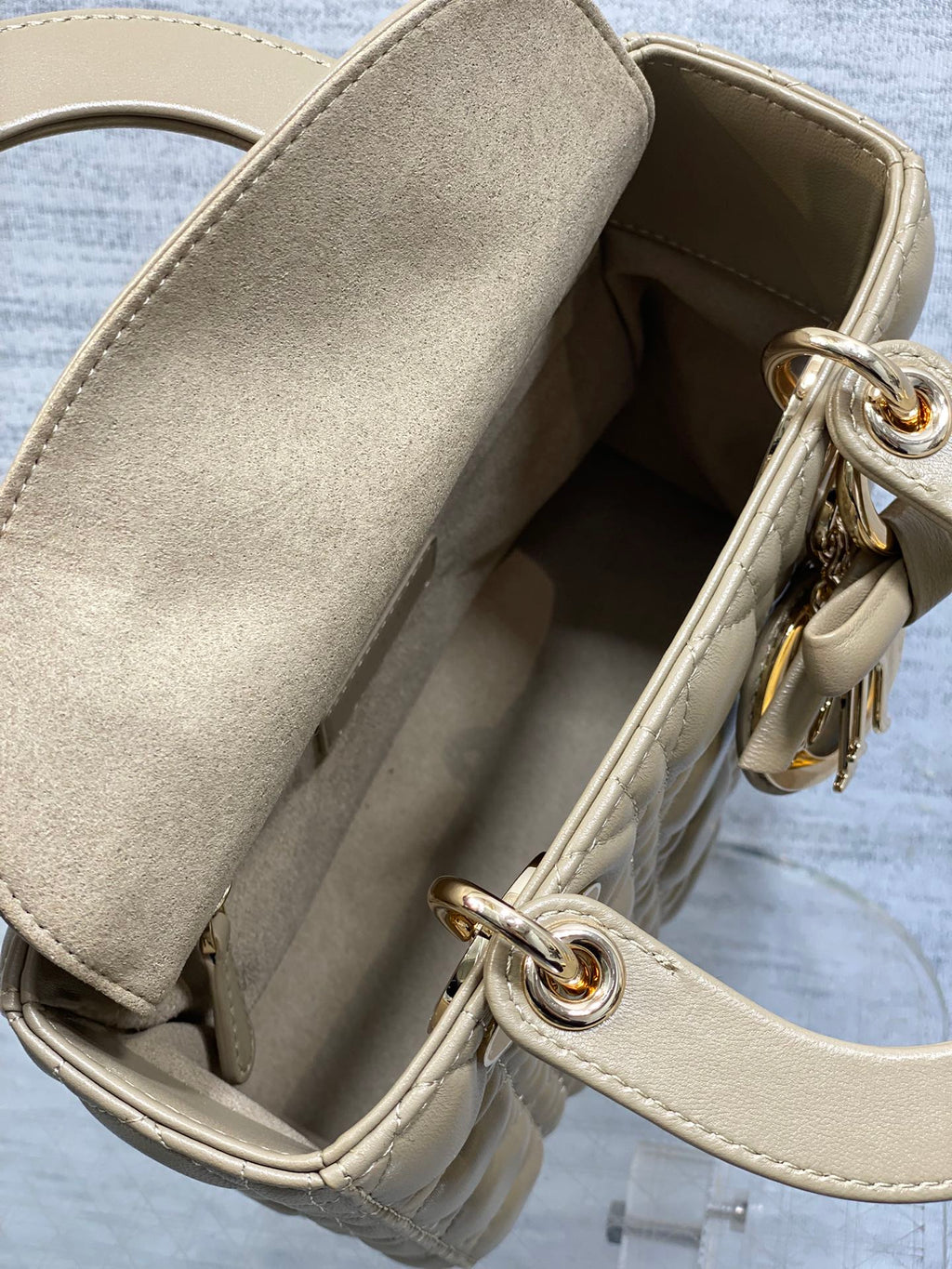 Dior quilted handbag interior view with beige lining and gold-tone ring hardware