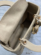Dior quilted handbag interior view with beige lining and gold-tone ring hardware