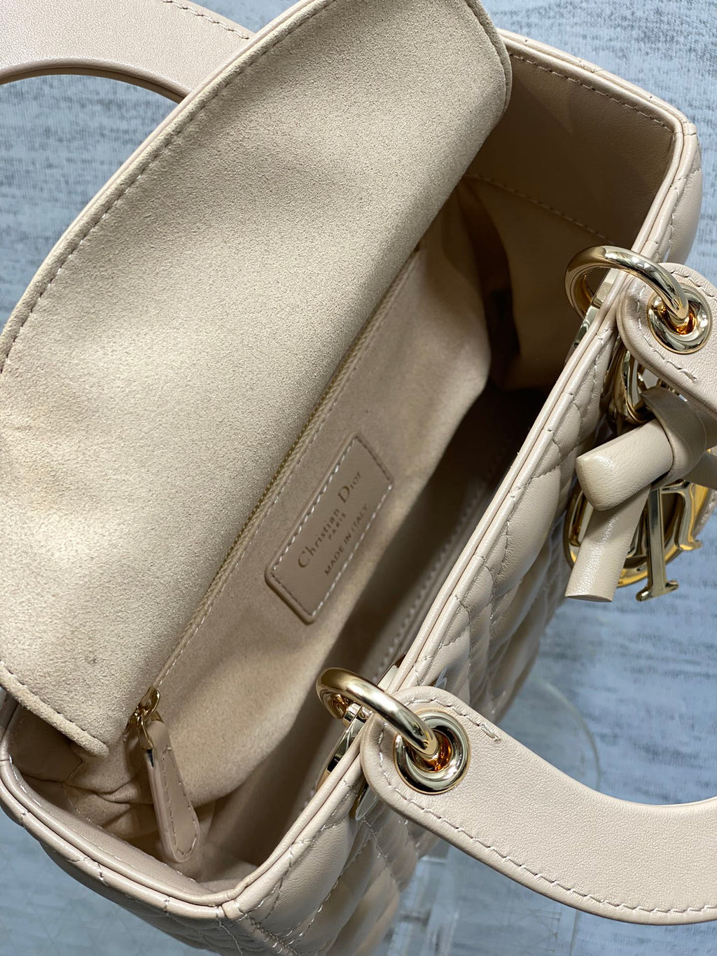 Dior beige handbag interior with fabric lining and metal ring strap hardware