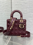 Burgundy quilted top-handle mini bag with gold-tone hardware and shoulder strap
