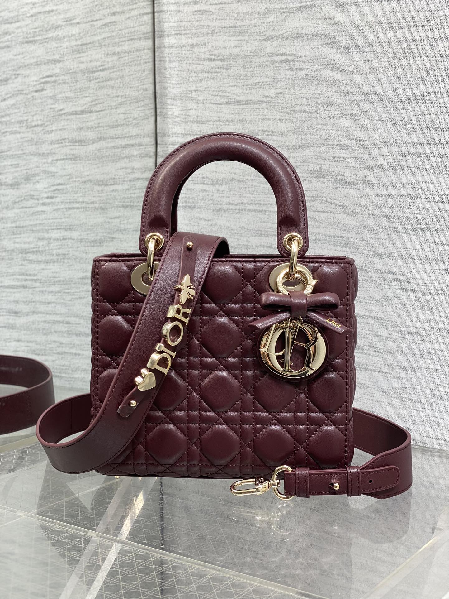Burgundy quilted top-handle mini bag with gold-tone hardware and shoulder strap