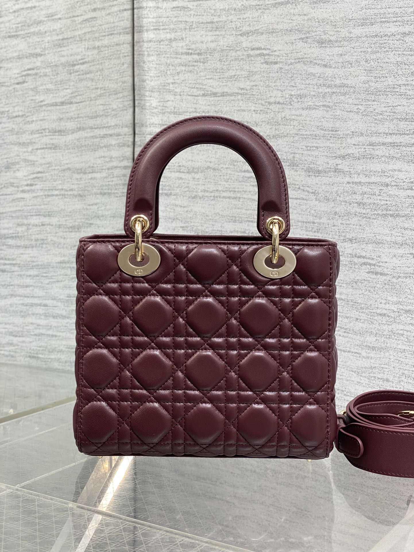 Burgundy quilted top-handle mini bag with gold-tone rings and side shoulder strap
