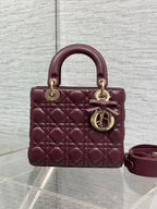 Burgundy quilted mini handbag with top handles, gold rings, and shoulder strap