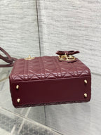 Burgundy quilted mini handbag back view with gold studs and short top handle