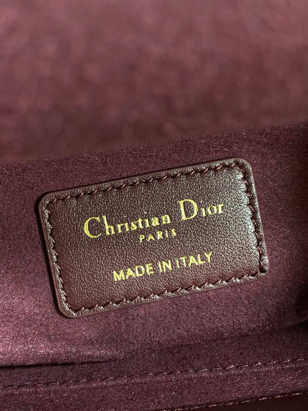 Burgundy leather label reading Christian Dior Paris, Made in Italy