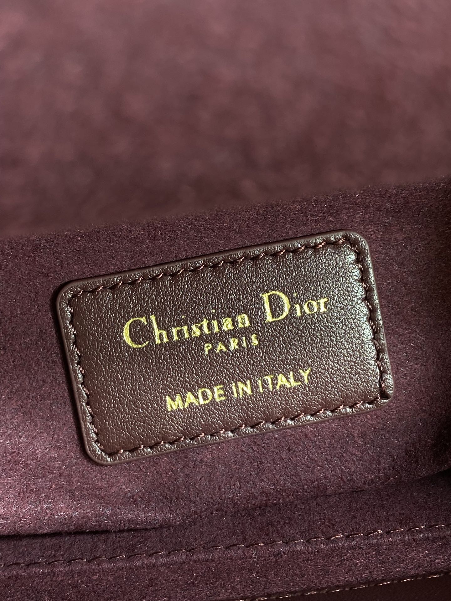 Burgundy leather label reading Christian Dior Paris, Made in Italy