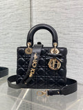 Black quilted mini handbag with top handle, bow accent, and gold-tone charms