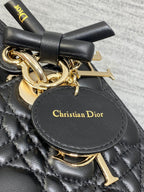 Black quilted handbag bow and gold-tone hardware with Christian Dior leather charm