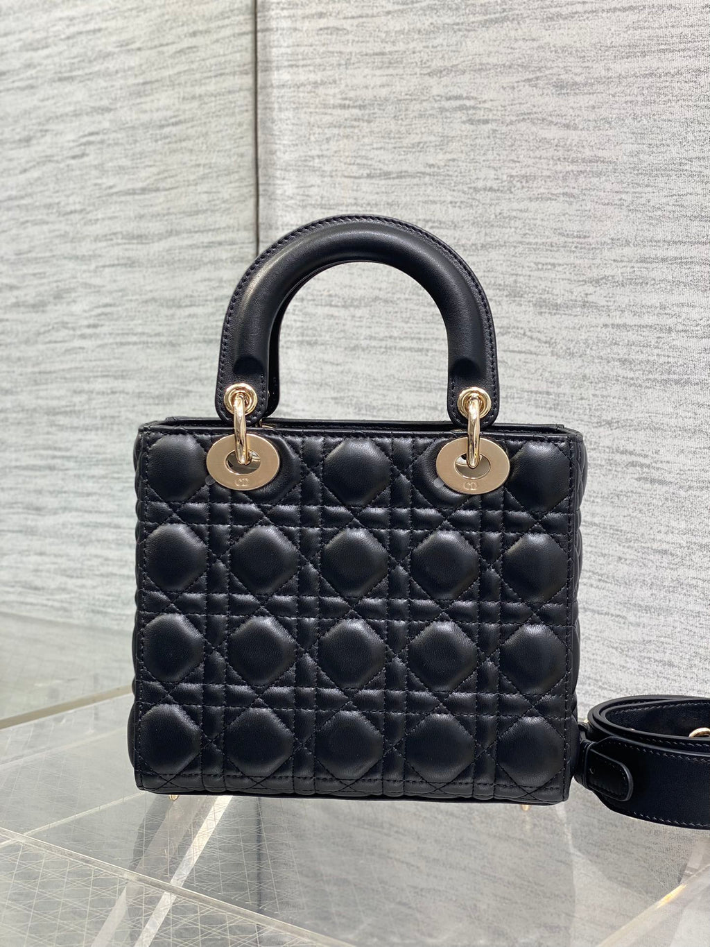Black quilted mini handbag with double top handles and gold-tone hardware
