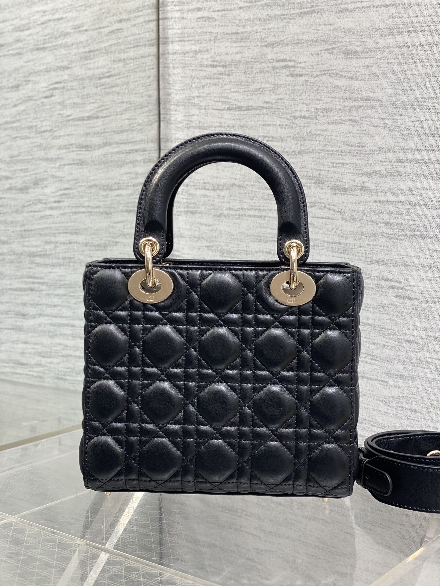 Black quilted mini handbag with double top handles and gold-tone hardware