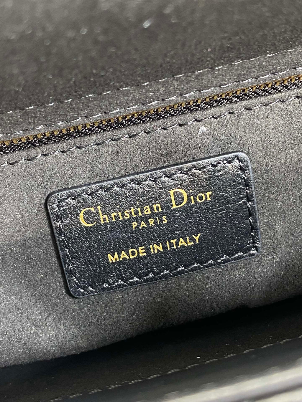 Close-up of interior label: Christian Dior Paris, Made in Italy on gray lining