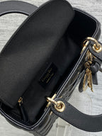 Black leather mini bag interior opening with gold-tone zipper and D-ring charm
