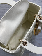 White handbag interior with open top and gold-tone clasp hardware