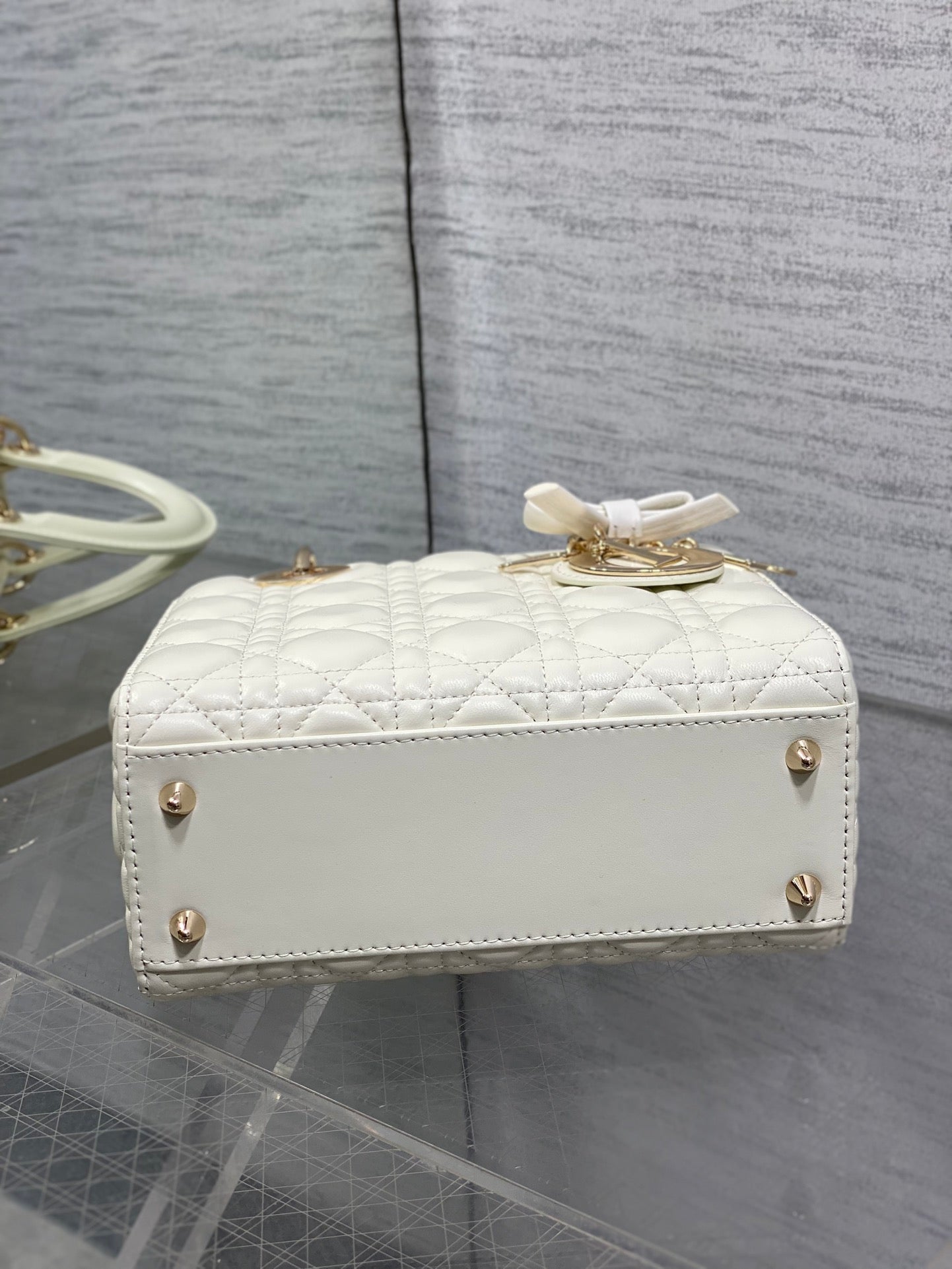 White quilted top-handle handbag with front leather band and bow
