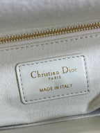 White leather bag label reading Christian Dior Paris, made in Italy