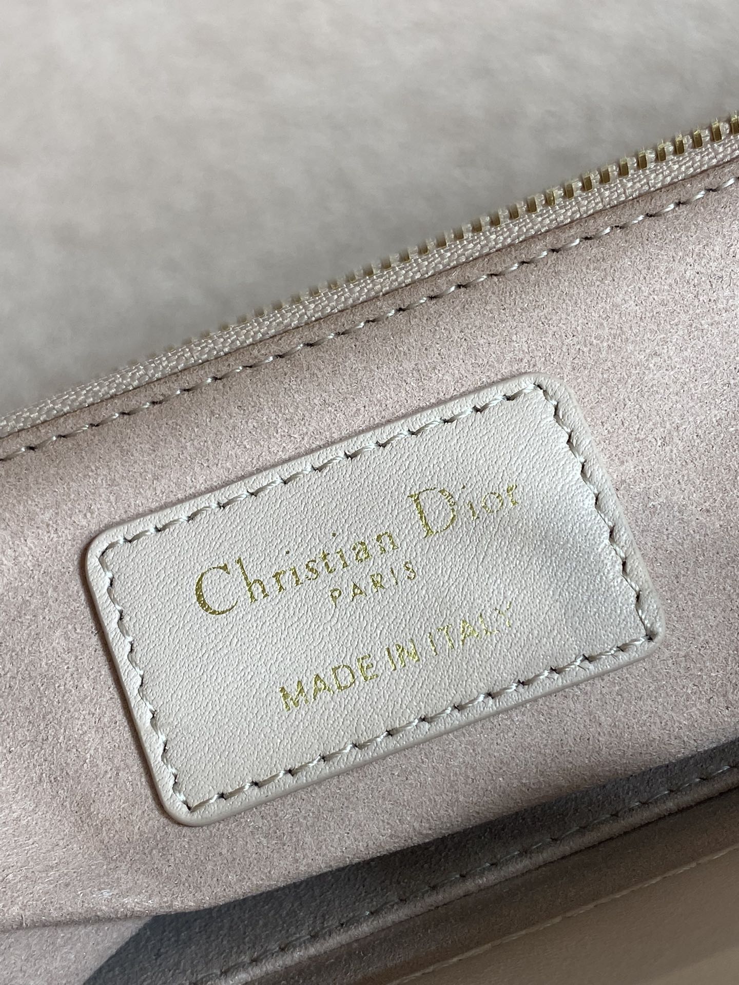Light pink handbag leather patch label reading "Christian Dior" MADE IN"