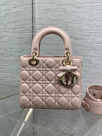 Light pink quilted mini handbag with top handles, bow charm, and adjustable strap