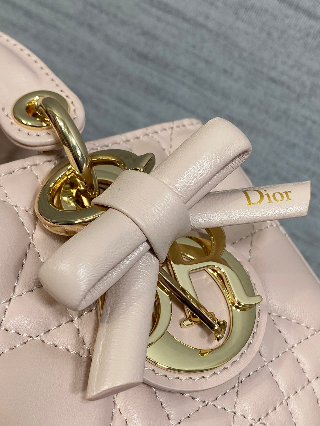 Dior bag bow and gold clasp detail on pale pink quilted leather