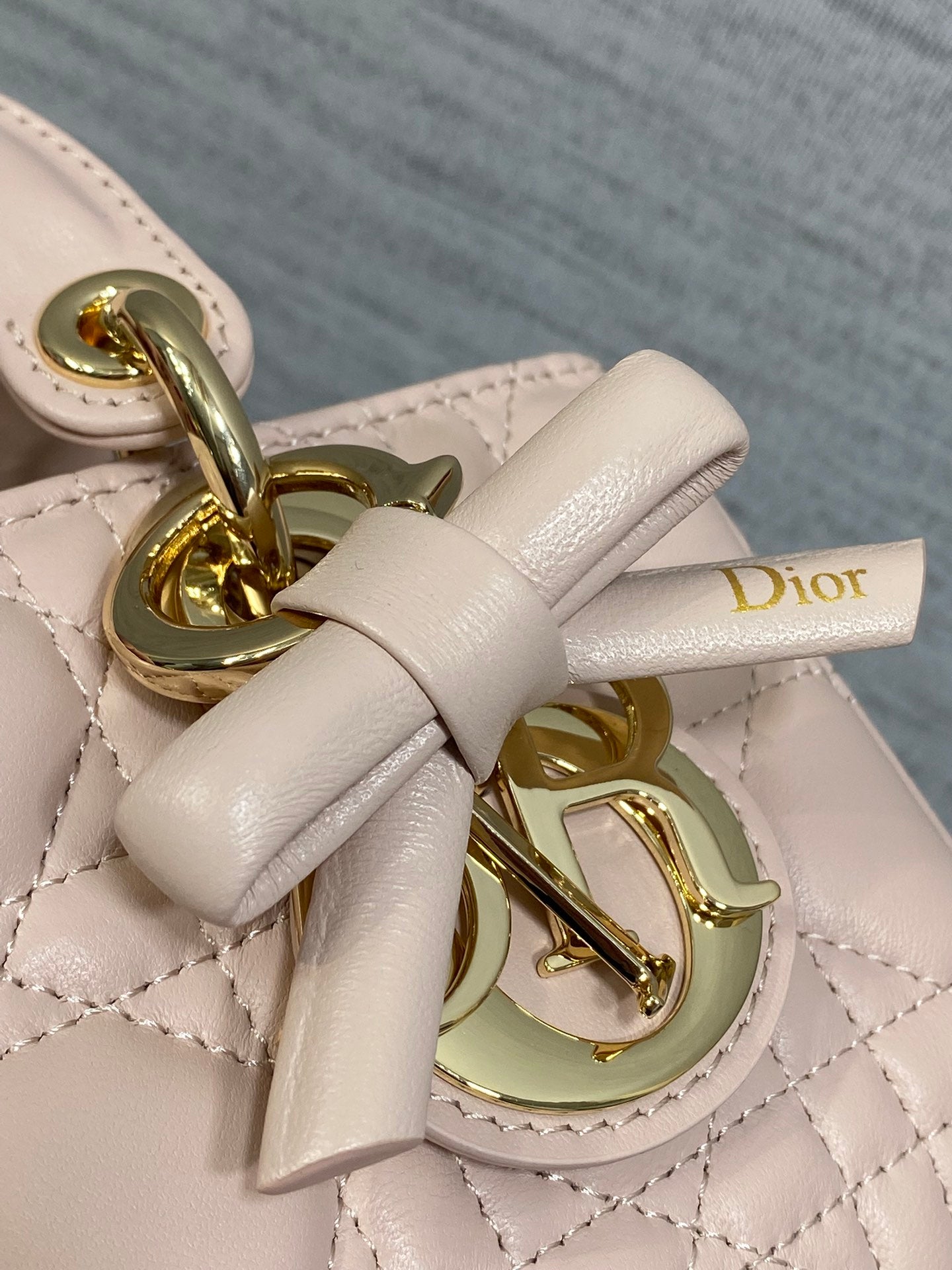 Dior bag bow and gold clasp detail on pale pink quilted leather