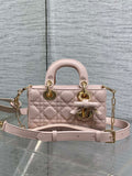Dior bag in pale pink quilted leather with top handles, bow detail, and gold chain strap