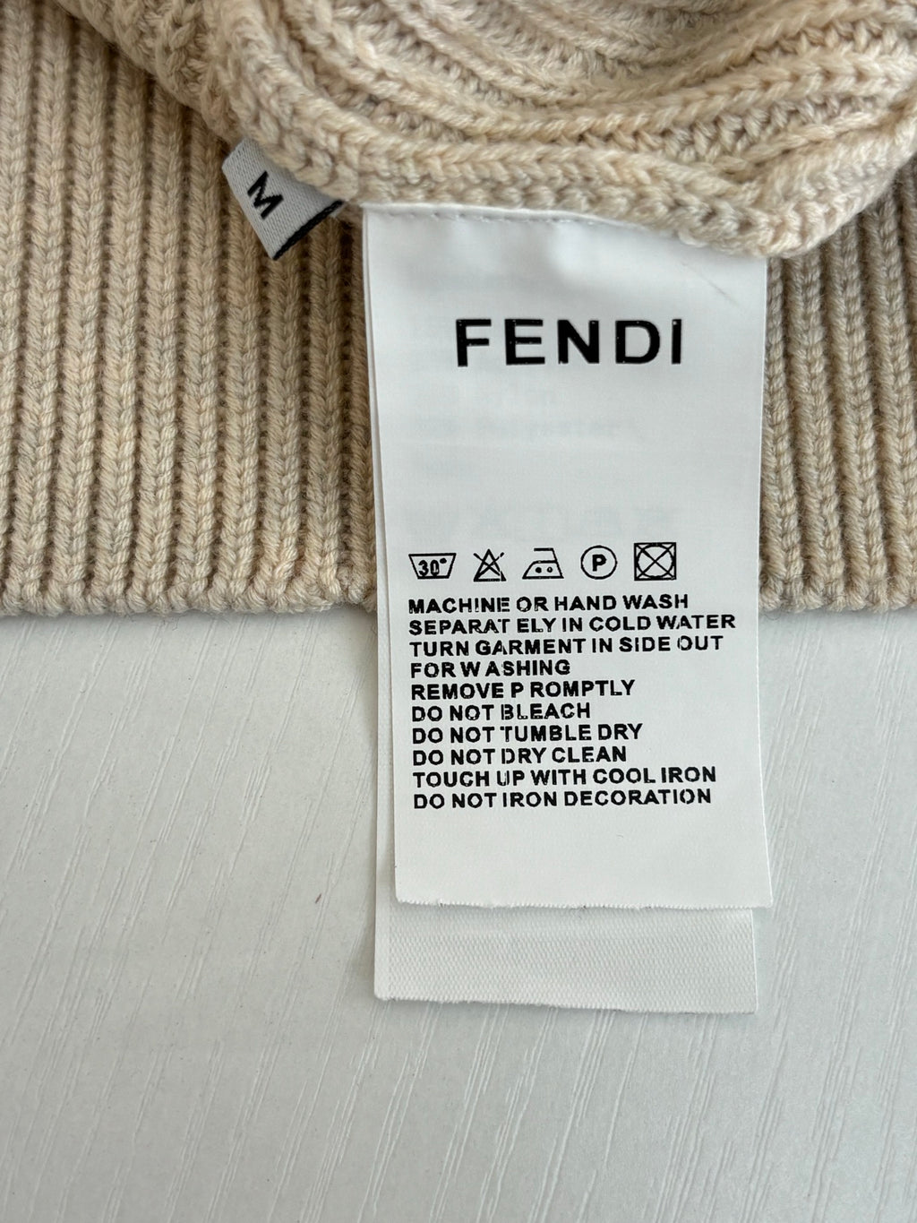 Fendi care label on cream knit sweater with washing instructions
