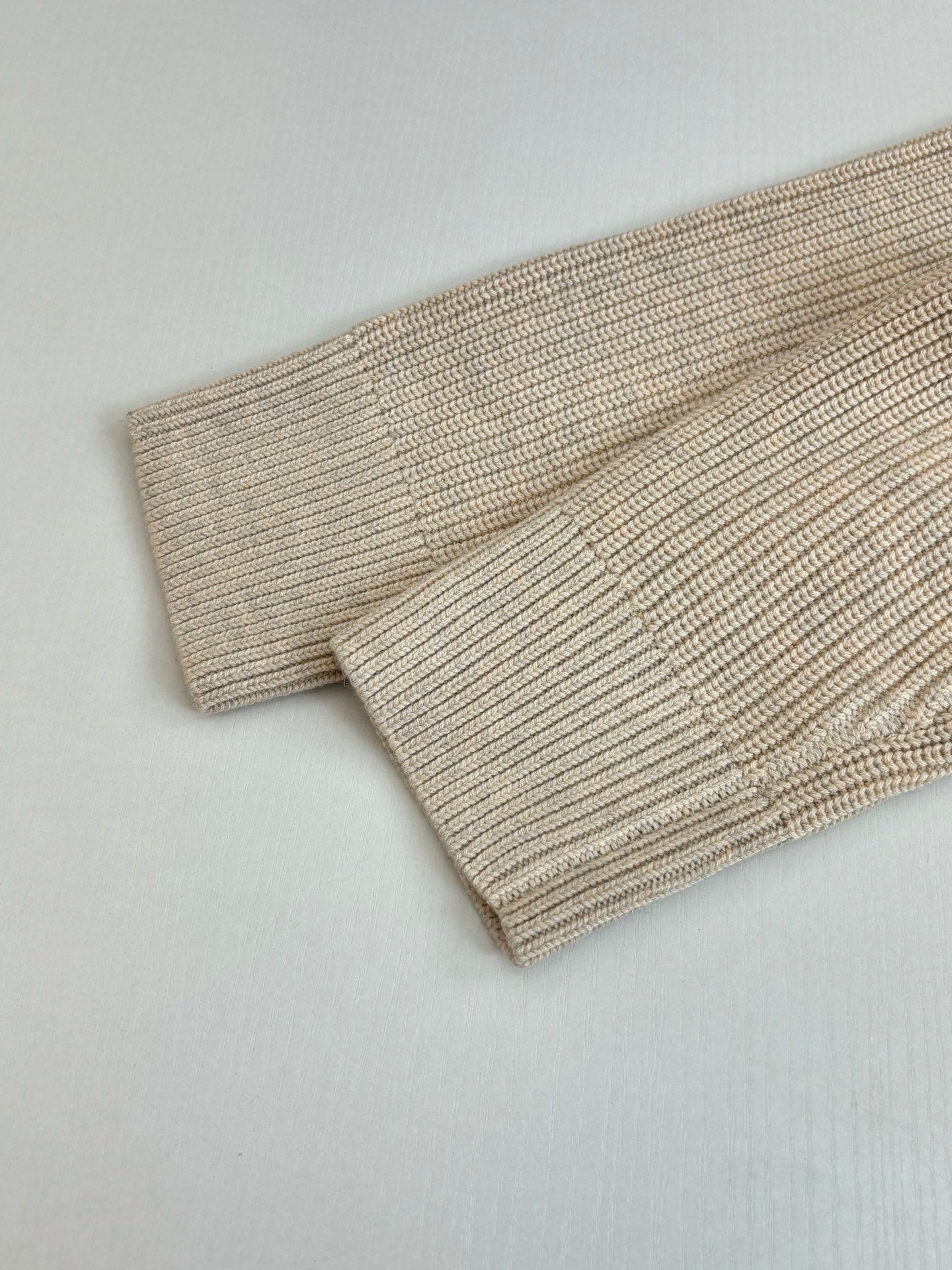 Cream ribbed knit sweater cuff and hem detail