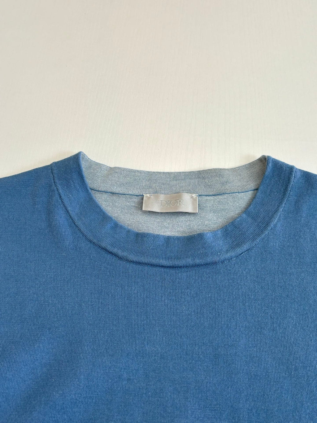 Blue crew-neck T-shirt collar with size label tag