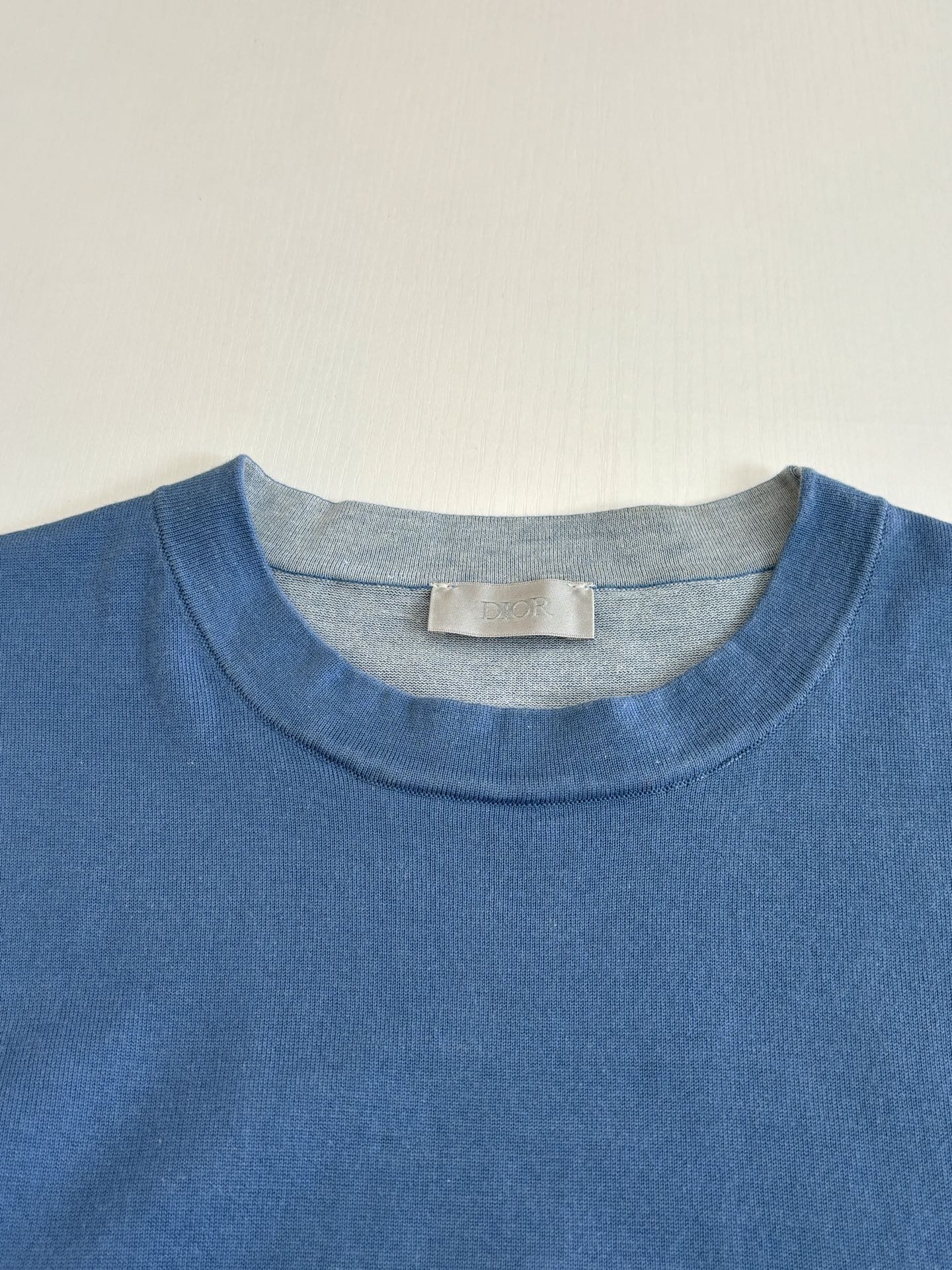 Blue crew-neck T-shirt collar with size label tag