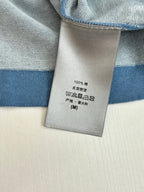 Blue T-shirt care label tag with 100% and size info