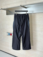 Balenciaga black wide-leg pants hanging on rack, elastic waistband and drawstring