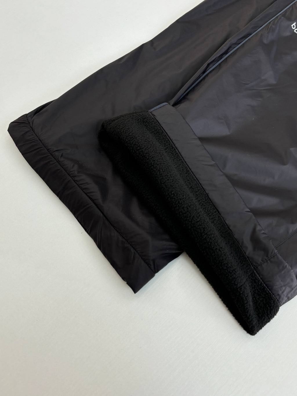 Balenciaga black pants with textured fabric and elastic cuffs, laid flat