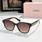 MiuMiu glasses with tortoiseshell frames and dark tinted lenses, front view