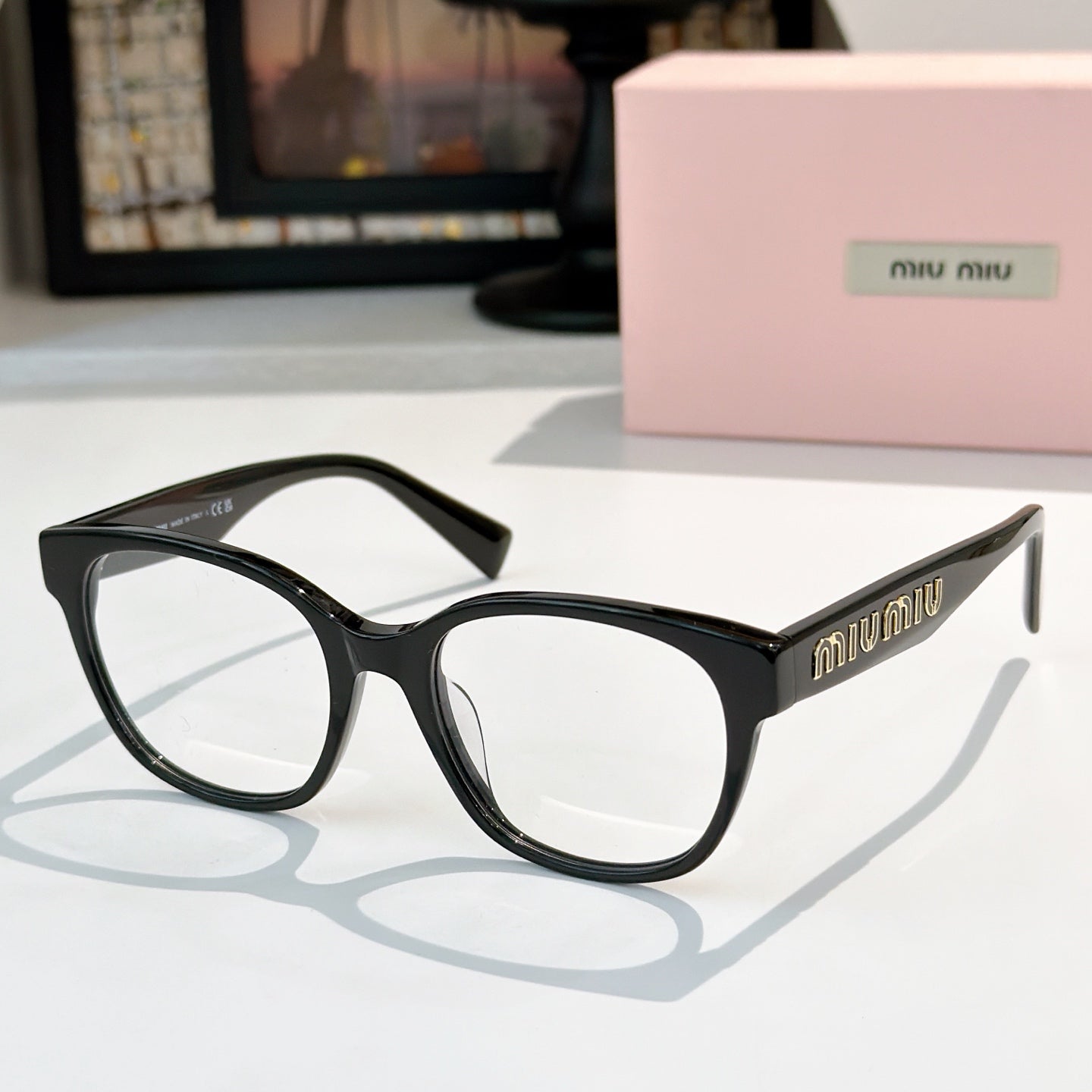 MiuMiu glasses with black frames and dark tinted lenses, front view