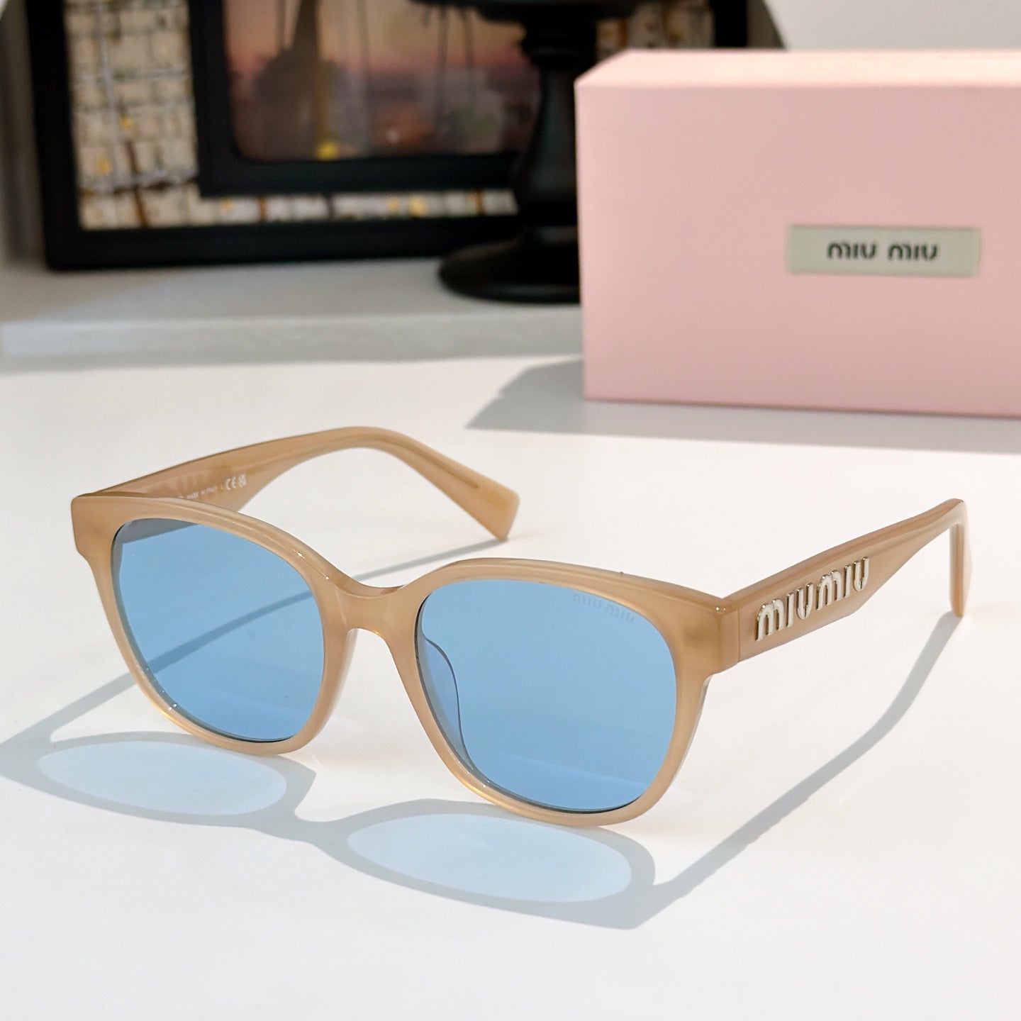 MiuMiu glasses with tan frames and blue tinted lenses, front view