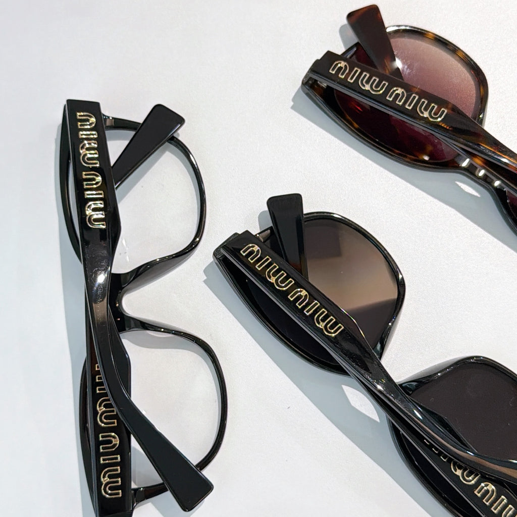 MiuMiu glasses with black frames and tinted lenses, close-up of frames