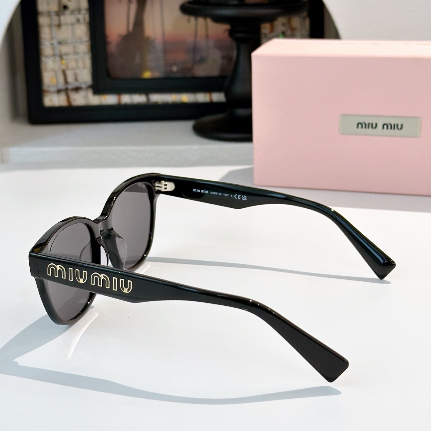MiuMiu glasses with black frames and dark tinted lenses, side view