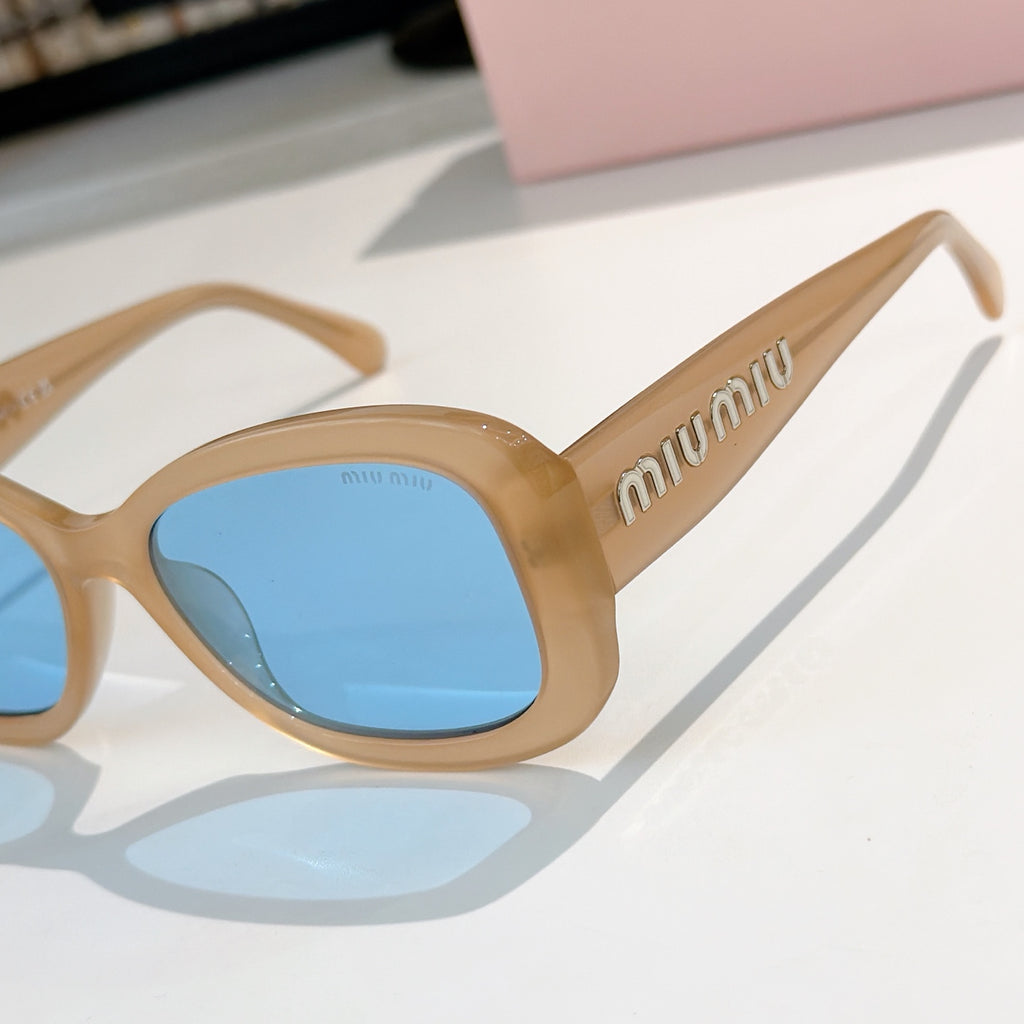 MiuMiu sunglasses in tan with blue gradient lenses, close-up angled view of front.