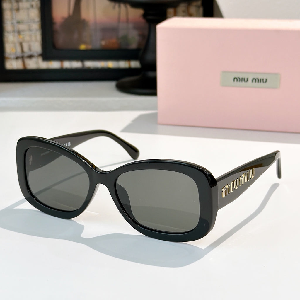 MiuMiu sunglasses with black frames and dark gray lenses, rounded cat-eye shape.