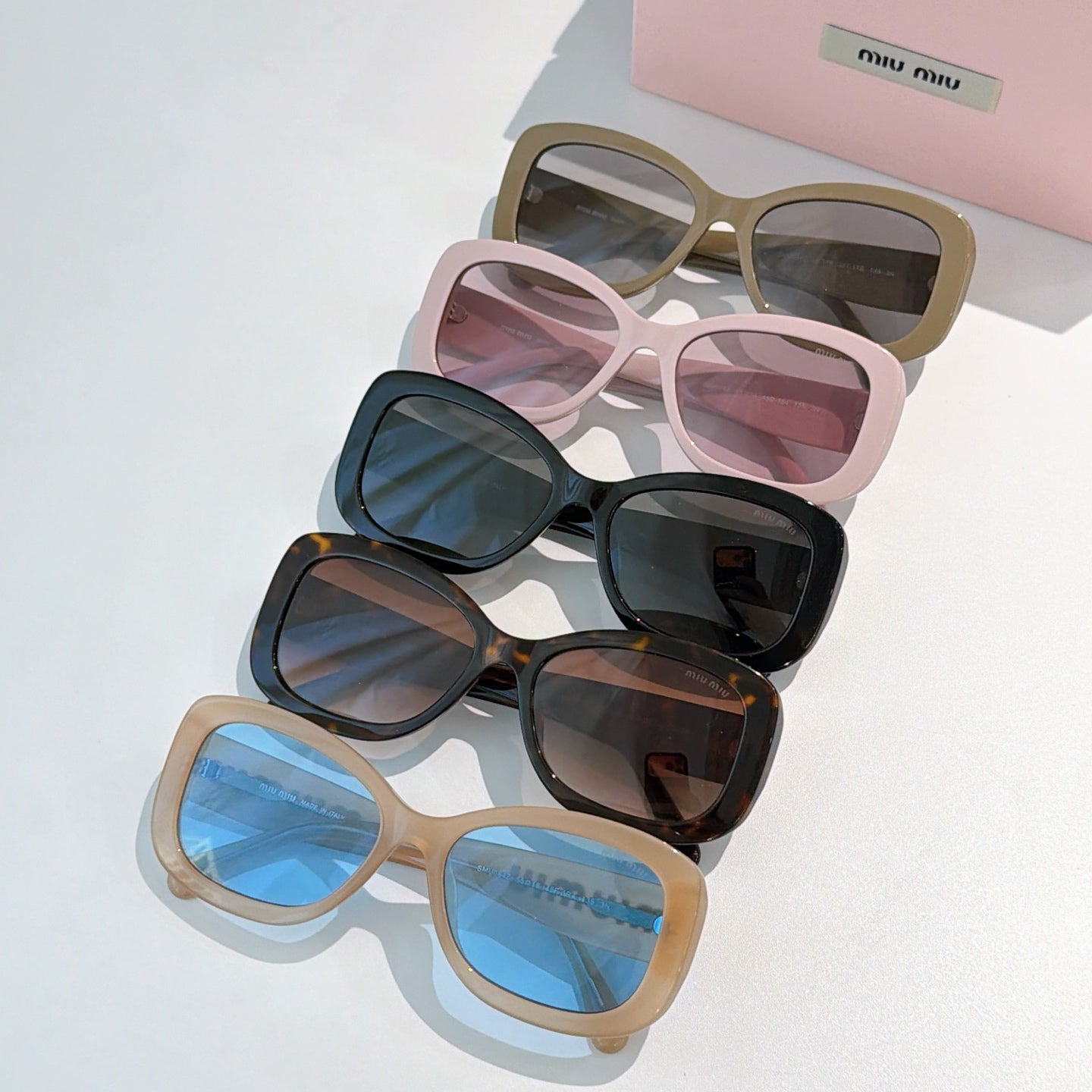 MiuMiu sunglasses group with tan, black, and pink frames and tinted lenses.