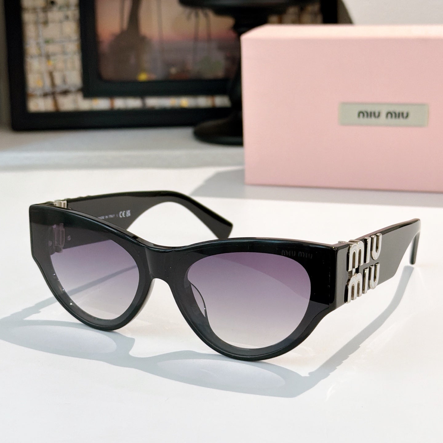 MiuMiu cat-eye sunglasses with dark frames and purple tinted lenses