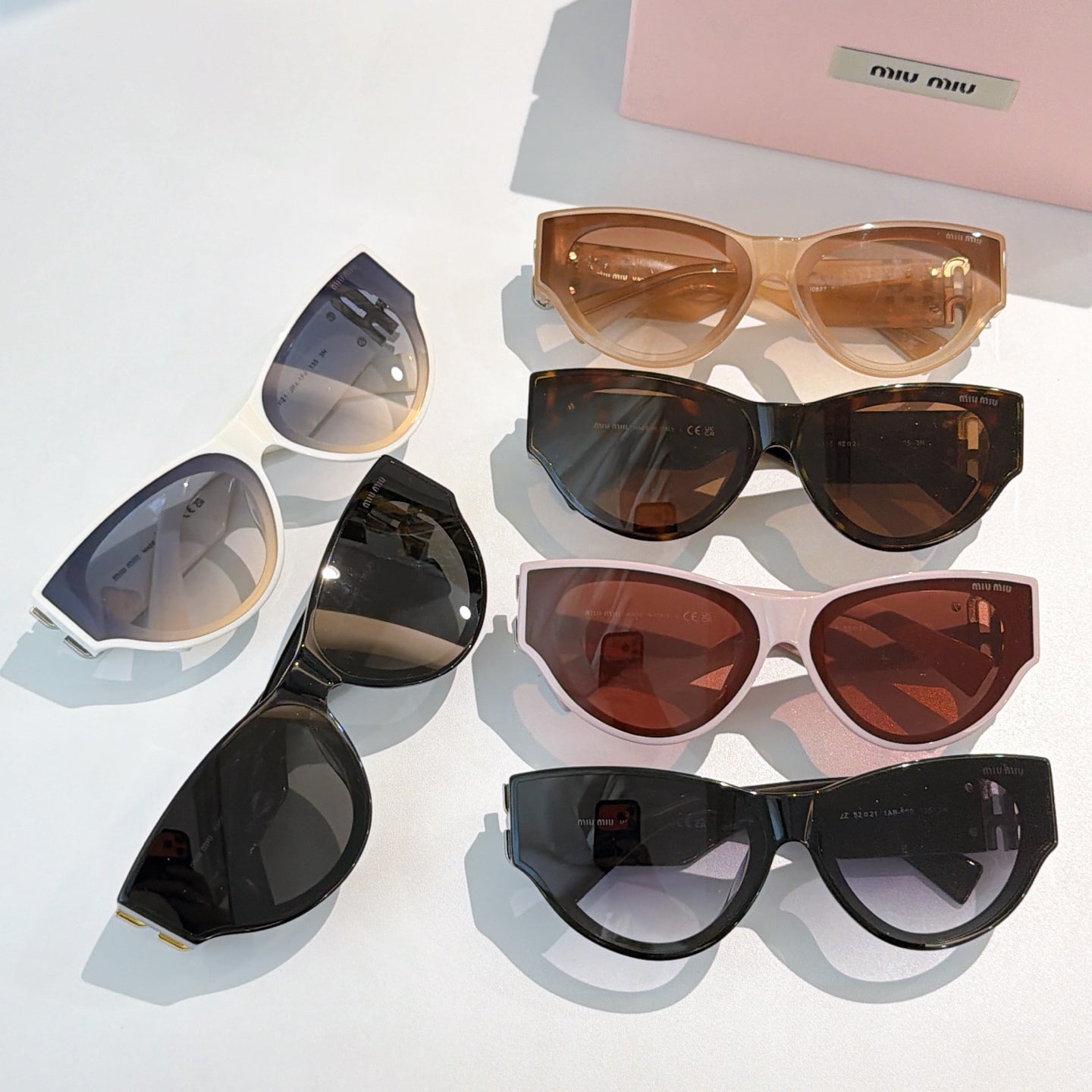 Set of MiuMiu cat-eye sunglasses with mixed frames and tinted lenses on display
