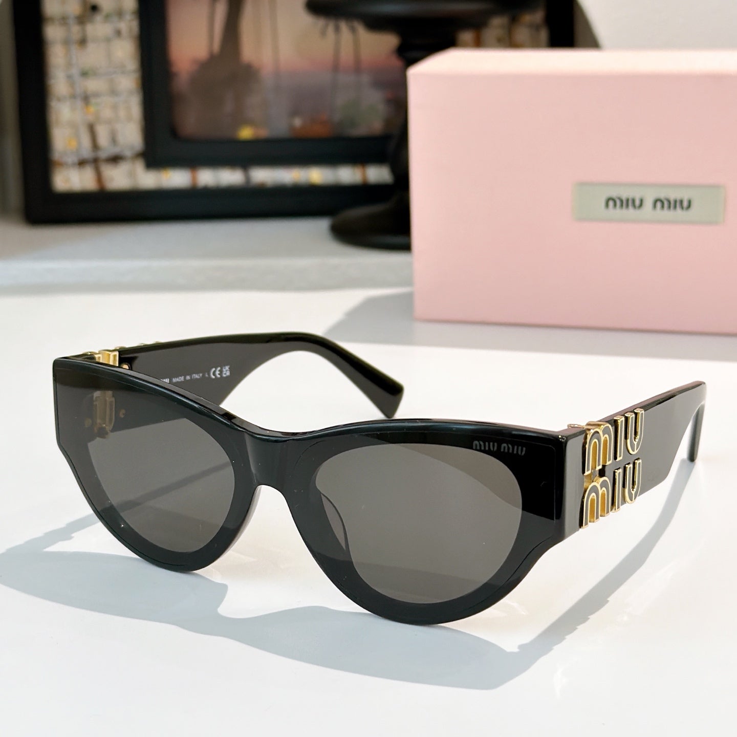 MiuMiu cat-eye sunglasses with black frames and smoky gray tinted lenses