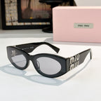 Black sunglasses with gray lenses and gold Miu Miu logo on the temples