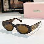 Tortoiseshell sunglasses with amber-brown lenses and gold Miu Miu logo on the temples