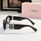 Black sunglasses with silver hardware and gold Miu Miu logo on the temples