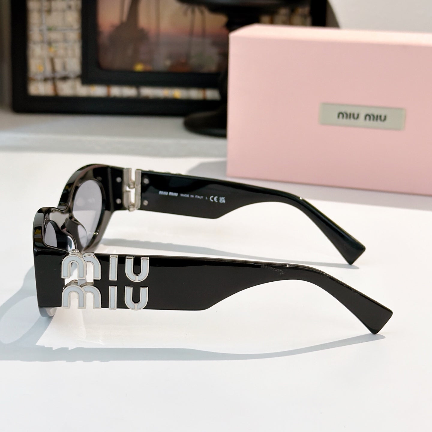 Black sunglasses with silver hardware and gold Miu Miu logo on the temples