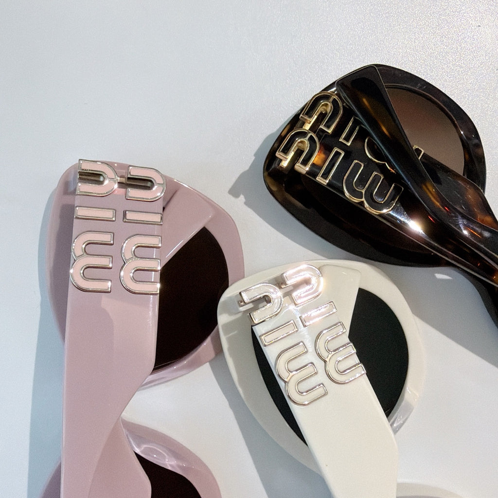 MiuMiu sunglasses logo arms close-up on pink and black frames