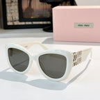 MiuMiu cat-eye sunglasses with white frames and dark gray tinted lenses, gold logo arms